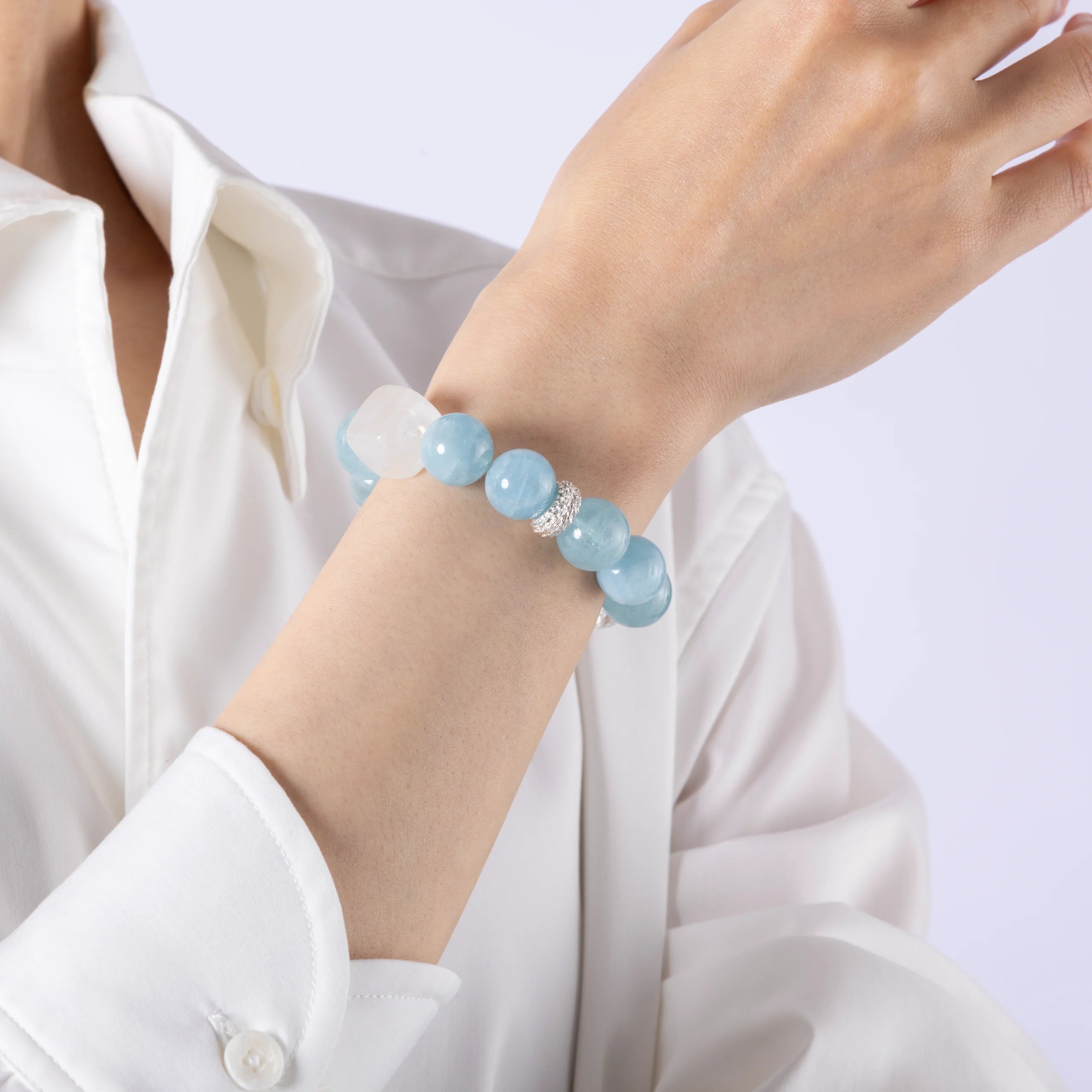 Model showing aquamarine gem bracelet on hand